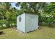 A weathered storage shed adds character to the yard, surrounded by trees and lush foliage at 601 S 12Th St, Leesburg, FL 34748
