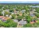 An aerial view showcases a residential neighborhood filled with mature trees and well-maintained homes, some with private pools and water views at 6316 Marlberry Dr, Orlando, FL 32819