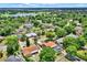 An aerial shot of a suburban community featuring green spaces, a distant lake, and neatly arranged homes, many with private swimming pools at 6316 Marlberry Dr, Orlando, FL 32819