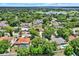 An elevated view capturing a charming residential neighborhood with tree-lined streets, homes with pools, and serene lake views in the distance at 6316 Marlberry Dr, Orlando, FL 32819