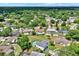 An aerial shot features a peaceful neighborhood with ample green space, swimming pools, and glimpses of a tranquil lake in the background at 6316 Marlberry Dr, Orlando, FL 32819