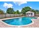 Inviting backyard oasis featuring a pristine pool and charming storage shed at 6316 Marlberry Dr, Orlando, FL 32819