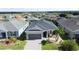 Aerial view of a well-maintained single-story home featuring lush landscaping in a residential neighborhood at 655 Conservation Blvd, Groveland, FL 34736