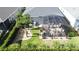 Aerial view of a home showcasing a screened-in patio, manicured lawn, rock gardens, and lush landscaping at 655 Conservation Blvd, Groveland, FL 34736