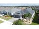 Aerial view of a well maintained home with a manicured lawn in a quiet neighborhood near a pond at 655 Conservation Blvd, Groveland, FL 34736