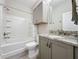 Updated bathroom with granite countertop, gray cabinets, and modern fixtures at 655 Conservation Blvd, Groveland, FL 34736
