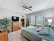 Bright bedroom featuring a ceiling fan, large dresser, and a comfortable bed with plush pillows and a blue quilt at 655 Conservation Blvd, Groveland, FL 34736