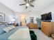 Serene bedroom with a comfortable bed, wooden dresser, large screen TV, and an ensuite bathroom for added convenience at 655 Conservation Blvd, Groveland, FL 34736