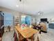 Open dining and living area with wood table set, gray flooring, and natural light from sliding glass door at 655 Conservation Blvd, Groveland, FL 34736