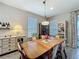Bright dining room features a pendant light, built-in hutch, and sleek, gray wood-look tile flooring at 655 Conservation Blvd, Groveland, FL 34736