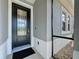 Close-up of the front door featuring decorative glass, black hardware, and neutral exterior paint at 655 Conservation Blvd, Groveland, FL 34736