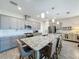 Spacious kitchen features a large granite island with bar seating, gray cabinets and stainless appliances at 655 Conservation Blvd, Groveland, FL 34736
