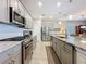 Updated kitchen with stainless steel appliances and gas range with open view to the dining area at 655 Conservation Blvd, Groveland, FL 34736