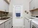 Well appointed laundry room with granite counters, a stainless sink and modern washer dryer combo, and ample storage at 655 Conservation Blvd, Groveland, FL 34736