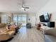 Cozy living space featuring tile floors, a ceiling fan, and sliding glass doors leading to the outdoor space at 655 Conservation Blvd, Groveland, FL 34736