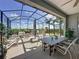 Relax on this large, screened-in patio with comfortable seating, a dining table, and views of the lush backyard at 655 Conservation Blvd, Groveland, FL 34736