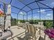 Enjoy outdoor living on this enclosed patio featuring comfortable seating, a dining table, and serene views of the garden at 655 Conservation Blvd, Groveland, FL 34736
