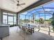 Enjoy the spacious screened-in patio with ceiling fan, dining table, and comfortable seating for relaxing and entertaining at 655 Conservation Blvd, Groveland, FL 34736
