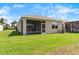 The well-manicured lawn featuring a screened-in patio at 8128 Penrose Pl, Wildwood, FL 34785