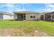 View of the house backyard with a screened lanai and green grass at 8128 Penrose Pl, Wildwood, FL 34785