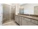 Bathroom with glass shower enclosure, double sinks, and granite countertops at 8128 Penrose Pl, Wildwood, FL 34785