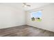 Bright bedroom with wood-look floors, ceiling fan, and a large window at 8128 Penrose Pl, Wildwood, FL 34785