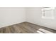Clean bedroom with wood-look floors, a window, and neutral paint, creating a relaxing space at 8128 Penrose Pl, Wildwood, FL 34785