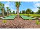 Community bocce ball court with landscaping, mature trees, and manicured grounds at 8128 Penrose Pl, Wildwood, FL 34785