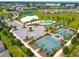 Resort-style community pool with palm trees, tennis courts, a clubhouse, and a parking area at 8128 Penrose Pl, Wildwood, FL 34785