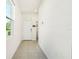 Bright home entryway showcasing tile flooring, closet and laundry area at 8128 Penrose Pl, Wildwood, FL 34785