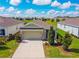 An aerial view of a modern single-Gathering home with a two-car garage at 8128 Penrose Pl, Wildwood, FL 34785