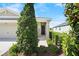 View of the covered front porch, enhanced by lush landscaping, next to the two-car garage at 8128 Penrose Pl, Wildwood, FL 34785