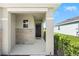 Covered front porch showing stone accents and view of the lawn, and the front door at 8128 Penrose Pl, Wildwood, FL 34785