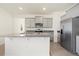 Modern kitchen featuring stainless steel appliances, gray cabinets, and a large granite island at 8128 Penrose Pl, Wildwood, FL 34785