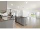 Open-concept kitchen featuring gray cabinets, stainless steel appliances, and an island with a sink at 8128 Penrose Pl, Wildwood, FL 34785