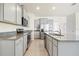 Spacious kitchen featuring stainless steel appliances, granite countertops, and gray cabinets at 8128 Penrose Pl, Wildwood, FL 34785