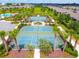 Aerial view of community pickleball courts and common areas with mature palm trees and pristine landscaping at 8128 Penrose Pl, Wildwood, FL 34785