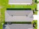 Aerial view of the home's roof and backyard featuring lush grass and a neighboring screened in lanai at 8128 Penrose Pl, Wildwood, FL 34785