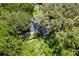 Aerial view of a charming home nestled amongst mature oak trees with manicured yard at 9223 Silver Lake Dr, Leesburg, FL 34788