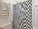 Bright bathroom features a white tile shower and tub combination, storage, and decorative shower curtain at 9223 Silver Lake Dr, Leesburg, FL 34788