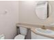 Simple, clean bathroom with sink, toilet, and a round mirror at 9223 Silver Lake Dr, Leesburg, FL 34788