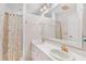 Bright bathroom featuring double sinks, shower/tub combo, and modern lighting at 9223 Silver Lake Dr, Leesburg, FL 34788