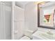 Bright bathroom features a shower, white fixtures, and an elegant mirror with access to an adjacent room at 9223 Silver Lake Dr, Leesburg, FL 34788