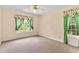 Light-filled bedroom with carpet, ceiling fan, neutral walls, and bright windows with decorative curtains at 9223 Silver Lake Dr, Leesburg, FL 34788