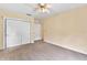 Bedroom with carpet, neutral walls, ceiling fan, closet, and access to other rooms is move-in ready at 9223 Silver Lake Dr, Leesburg, FL 34788