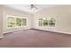A large, bright bedroom with carpet, a ceiling fan, and large windows offering ample natural light at 9223 Silver Lake Dr, Leesburg, FL 34788
