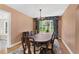 Elegant dining room with a long table set, chandelier, and a large window providing natural light at 9223 Silver Lake Dr, Leesburg, FL 34788