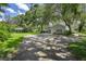 Long paved driveway leads to the home with mature trees providing shade and lush green lawns surrounding at 9223 Silver Lake Dr, Leesburg, FL 34788