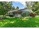 Rear exterior of the house with a fenced yard and lush greenery at 9223 Silver Lake Dr, Leesburg, FL 34788