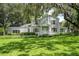 Charming two-story home with mature landscaping, lush green lawn, and beautiful Spanish moss-covered trees at 9223 Silver Lake Dr, Leesburg, FL 34788